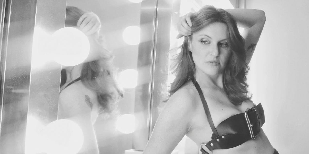model posing in a dressing room with vanity lights model posing in a dressing room with vanity lights
