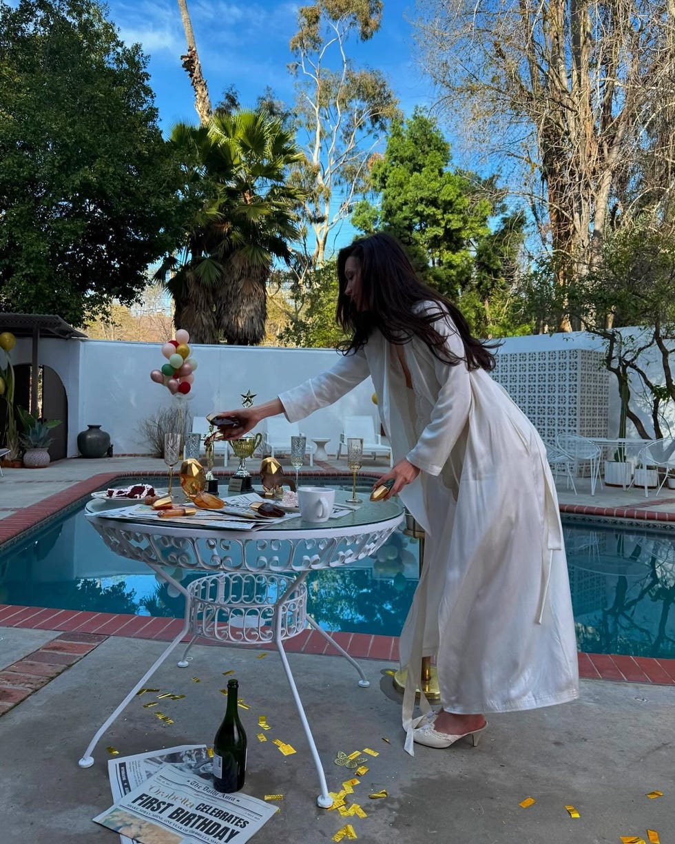 a celebration setup near a pool featuring a beautifully arranged table with food drinks and decorations