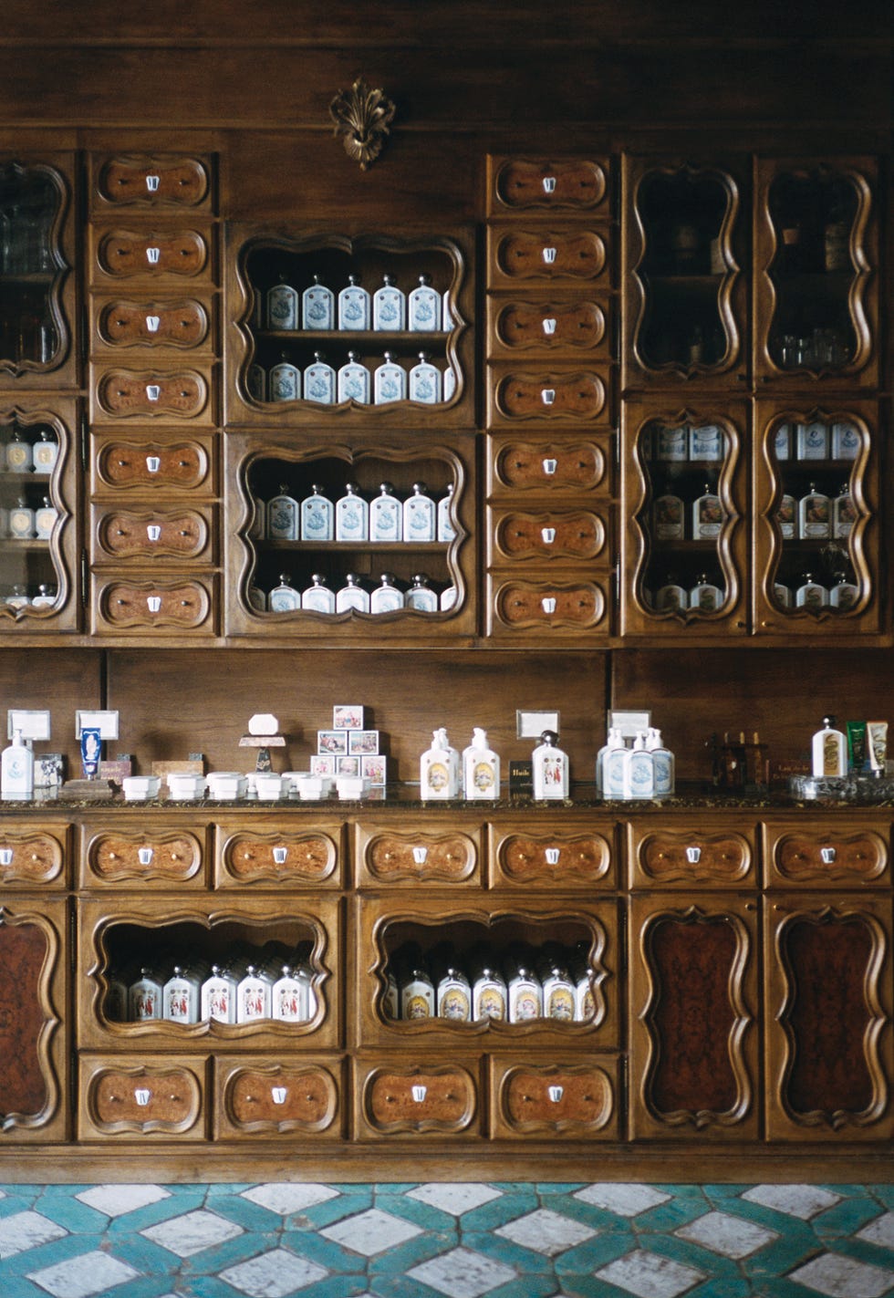 Display of antique shelves filled with various vintage bottles and jars.