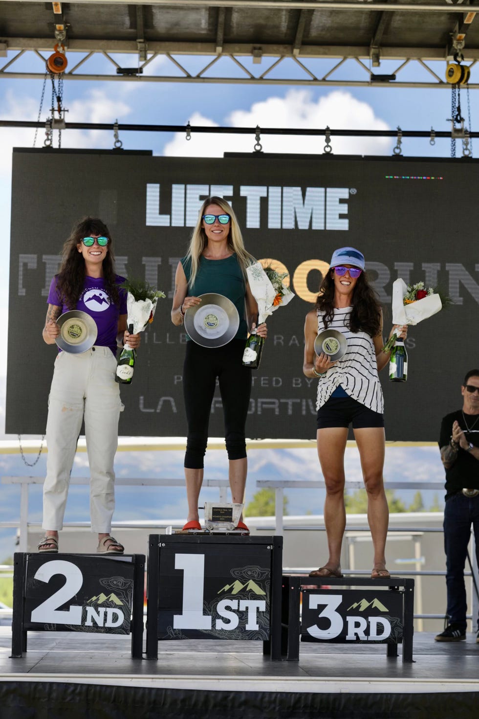 three runners standing on a podium