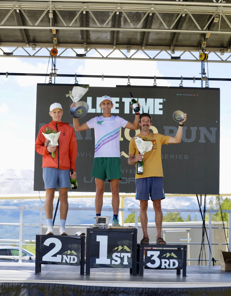 three runners standing on a podium