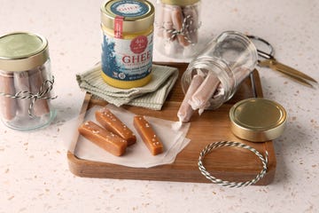 Ghee and candies on a wooden board with jars and decorative items