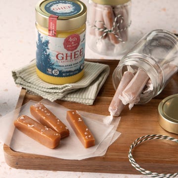 Ghee and candies on a wooden board with jars and decorative items Ghee and candies on a wooden board with jars and decorative items