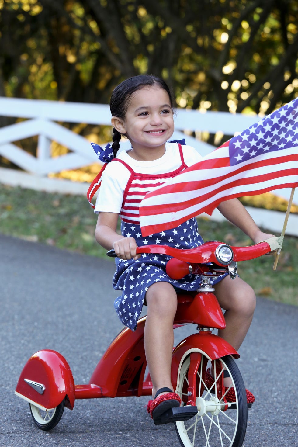 child riding patriotic bicycle with american flag