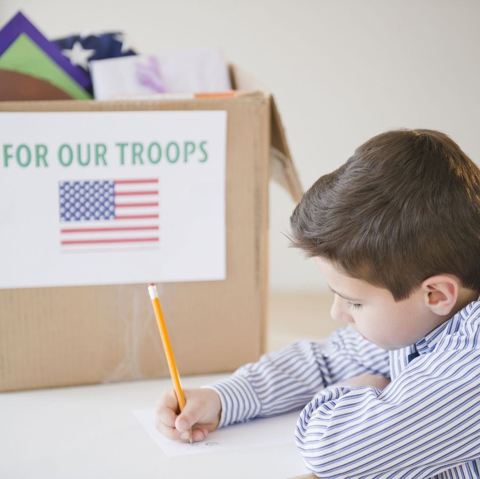 young boy preparing care package for us troops
