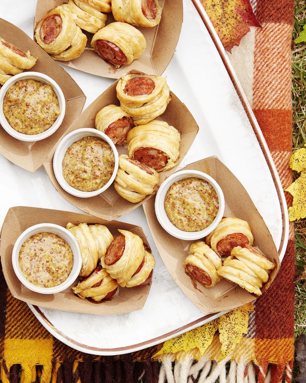 cajun sausage puffs in paper serving boats with condiment cups of bourbon mustard