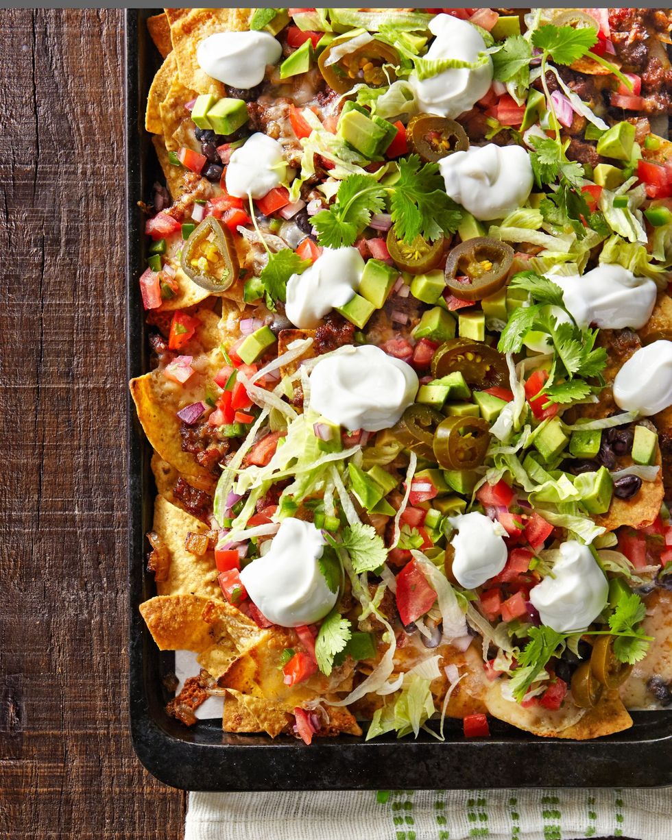 the best loaded nachos on a sheet pan and loaded with toppings