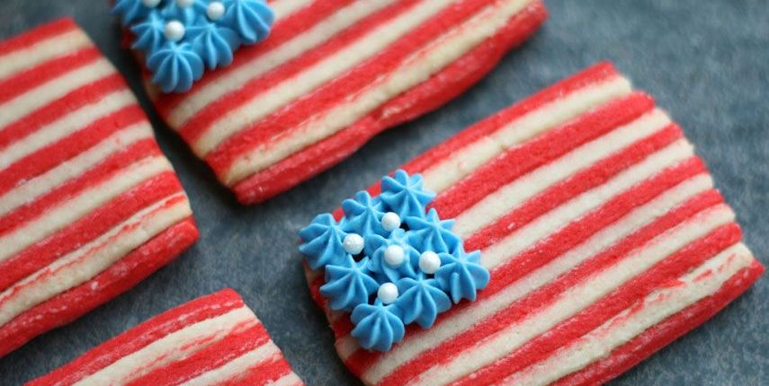 american flag sugar cookies with red and white cookie layers for the stripes and white sugar pearls on a square of piped blue frosting for the stars for a 4th of july celebration