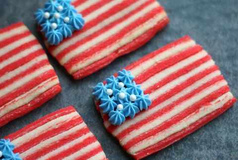 american flag sugar cookies with red and white cookie layers for the stripes and white sugar pearls on a square of piped blue frosting for the stars for a 4th of july celebration