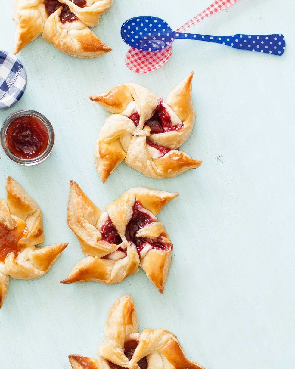 jam and cream cheese star shaped pastry pinwheels shown with blue polka and red gingham plastic spoons for 4th of july