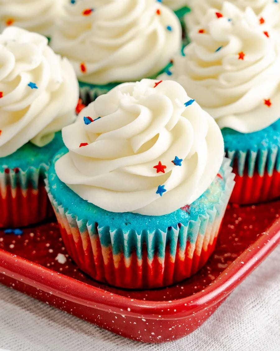 red white and blue cupcakes with white frosting and star sprinkles