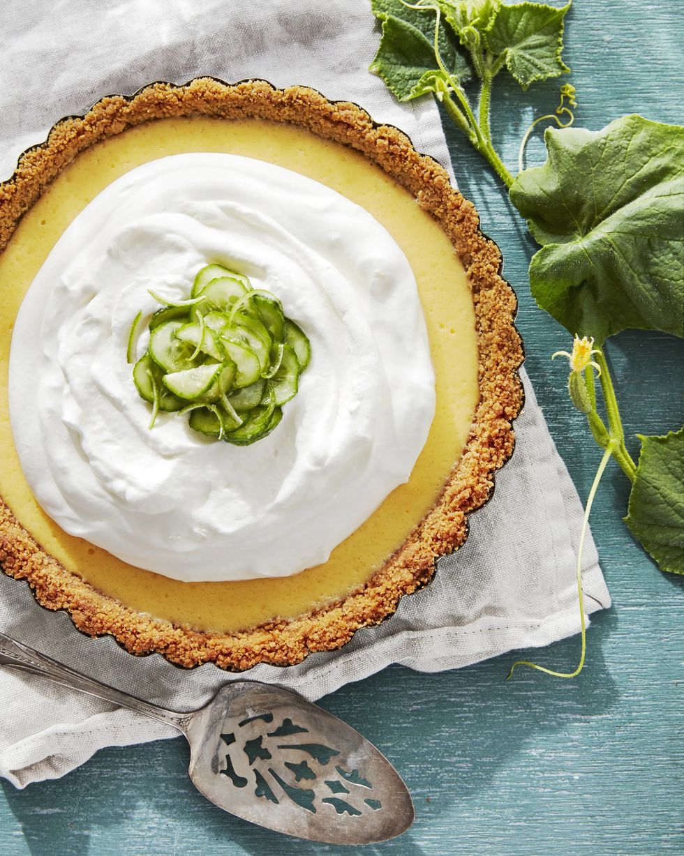 cucumber key lime pie in a baking dish with a mound of whipped cream and sliced cucumber garnish
