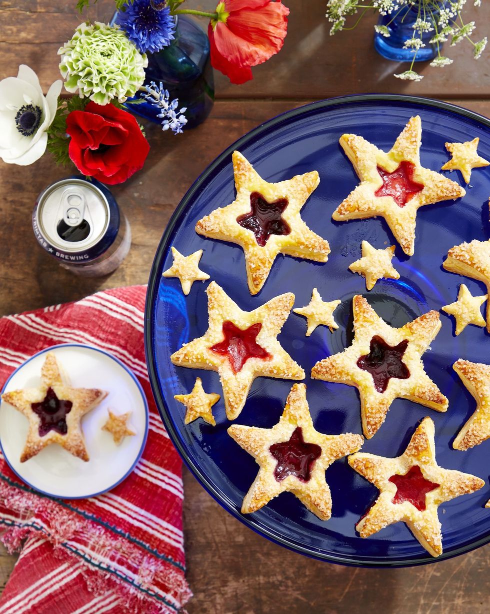 puff pastry star cookies with jam fillings in the centers and arranged on a blue cake stand