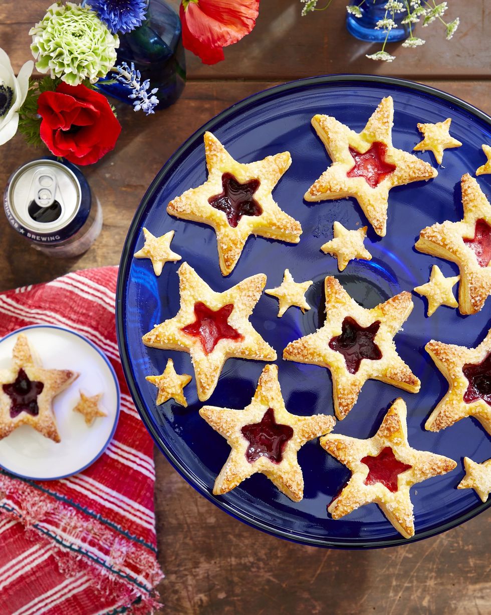puff pastry star cookies with jam fillings in the centers and arranged on a blue cake stand