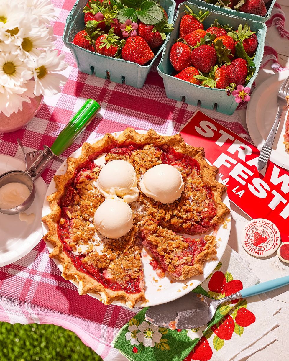 strawberry almond crumble pie on a picnic table with a strawberry festival bumper sticker