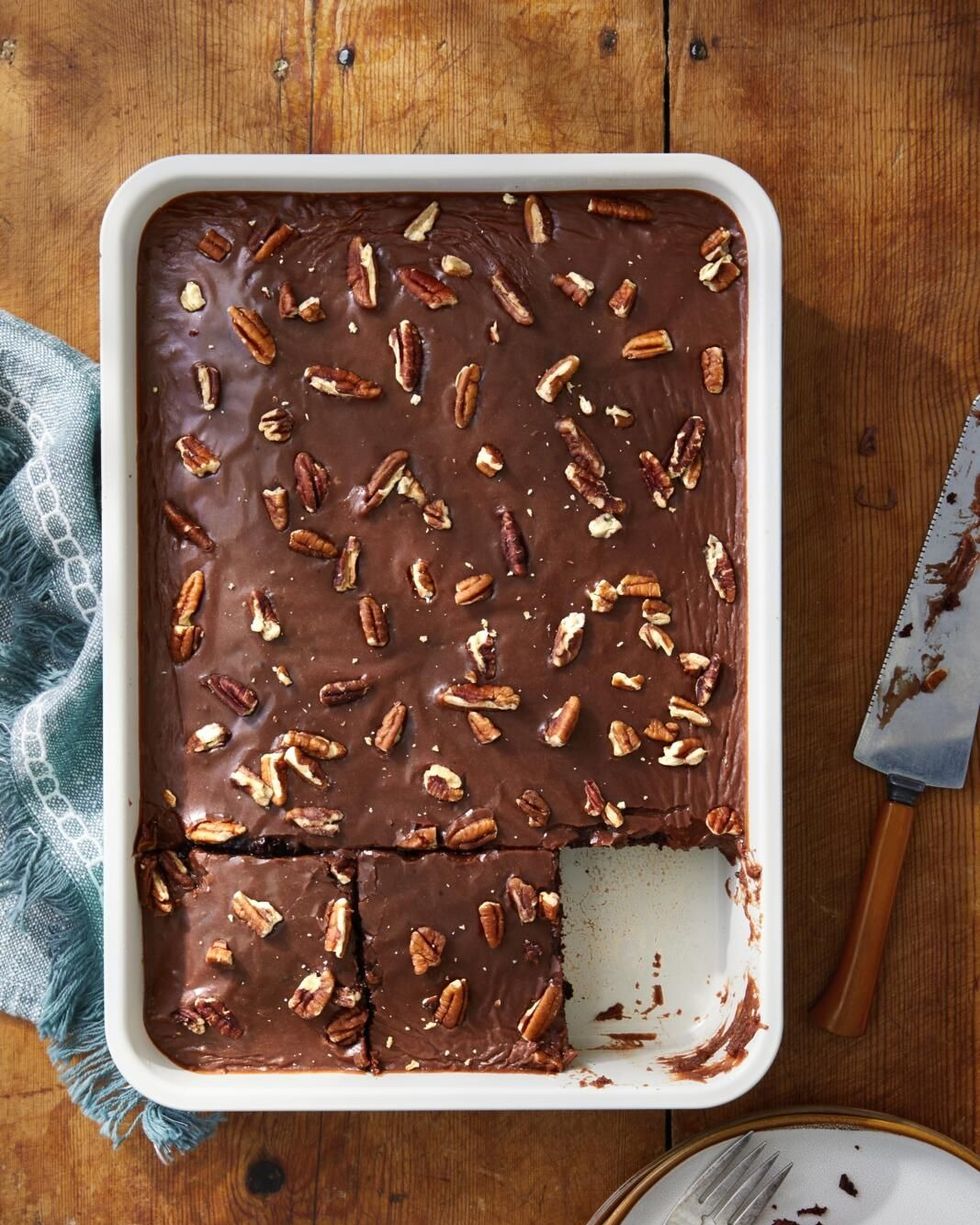 chocolate wacky cake baked in a rectangle pan with chocolate icing and chopped pecans on top