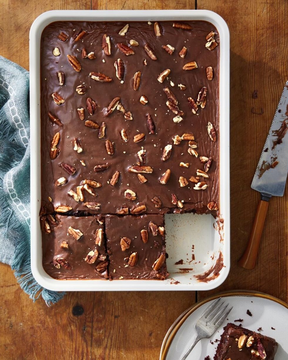 chocolate wacky cake baked in a rectangle pan with chocolate icing and chopped pecans on top