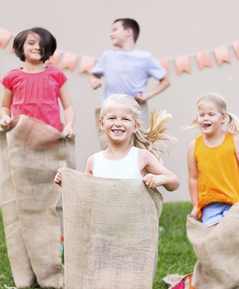 kids in burlap sacks competing in a sack race