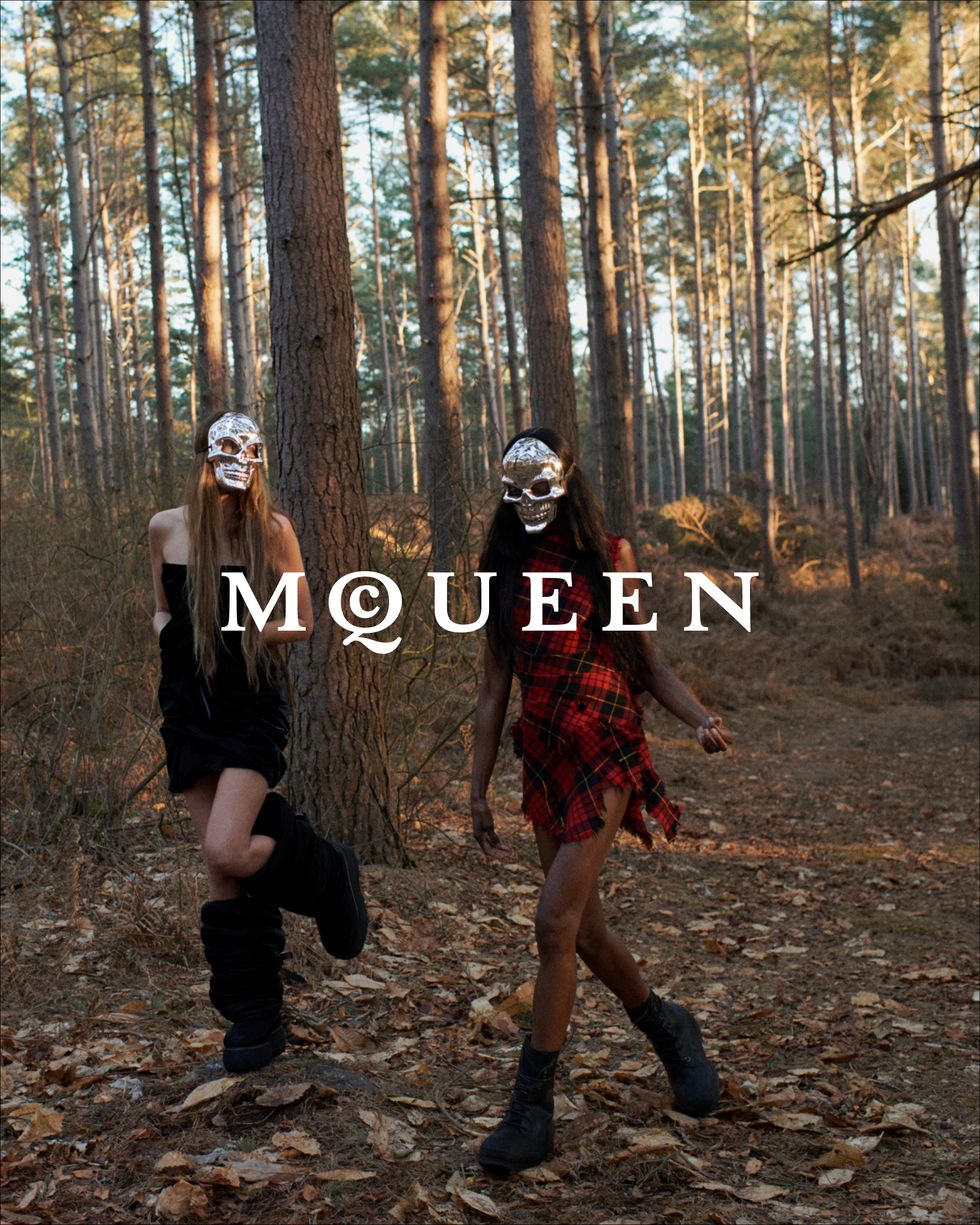 two people wearing masks and walking in a forest