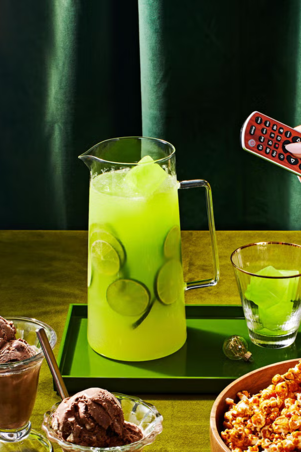 bright green punch in a pitcher with sliced limes