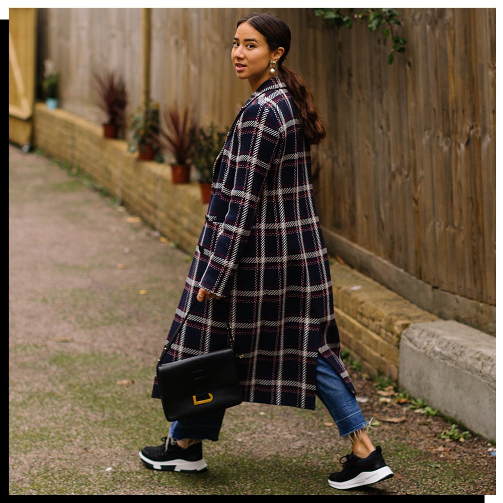 woman wearing oversized coat with trainers