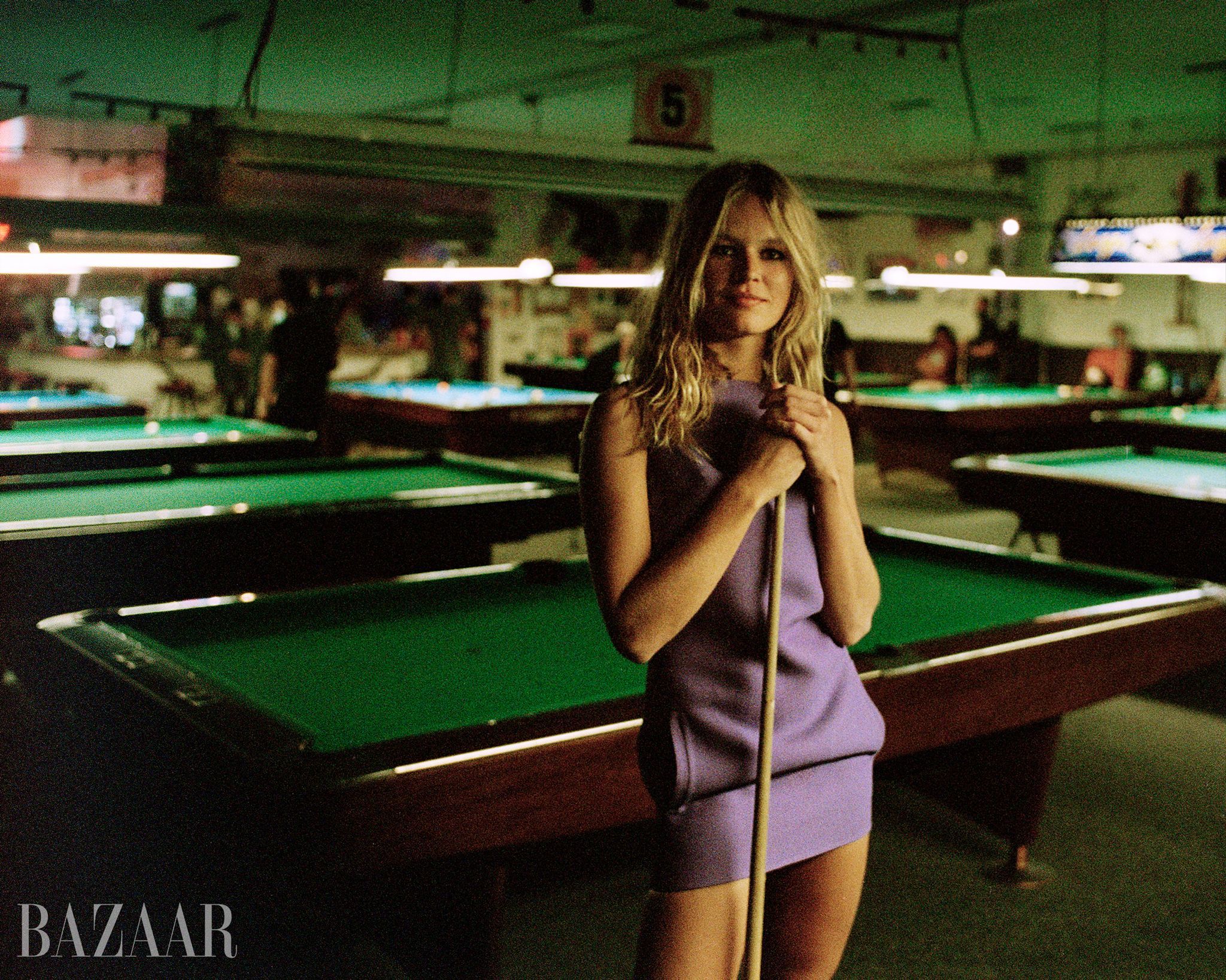 blonde model in lavender dress by pool tables