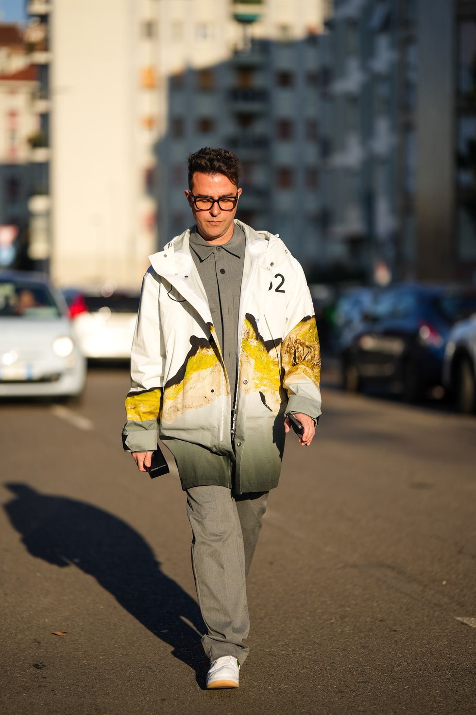 milan, italy january 13 a guest wears glasses, a gray shirt, a white and orange jacket, gray suit pants, white sneakers, outside jordanluca, during the milan fashion week menswear fallwinter 2024 2025 on january 13, 2024 in milan, italy photo by edward berthelotgetty images