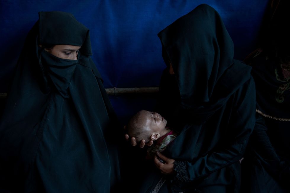 Zonder toegang tot de gezondheidszorg van Bangladesh wachten Rohingyavrouwen met ondervoede babys totdat ze worden gezien door artsen van internationale hulporganisaties