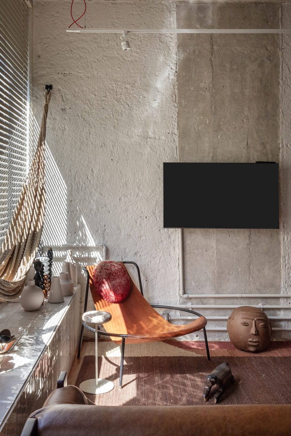 esta casa de 45 metros cuadrados es un estudio de arquitectura, un taller creativo y una zona de relax con hamaca, columpio y un bano triangular