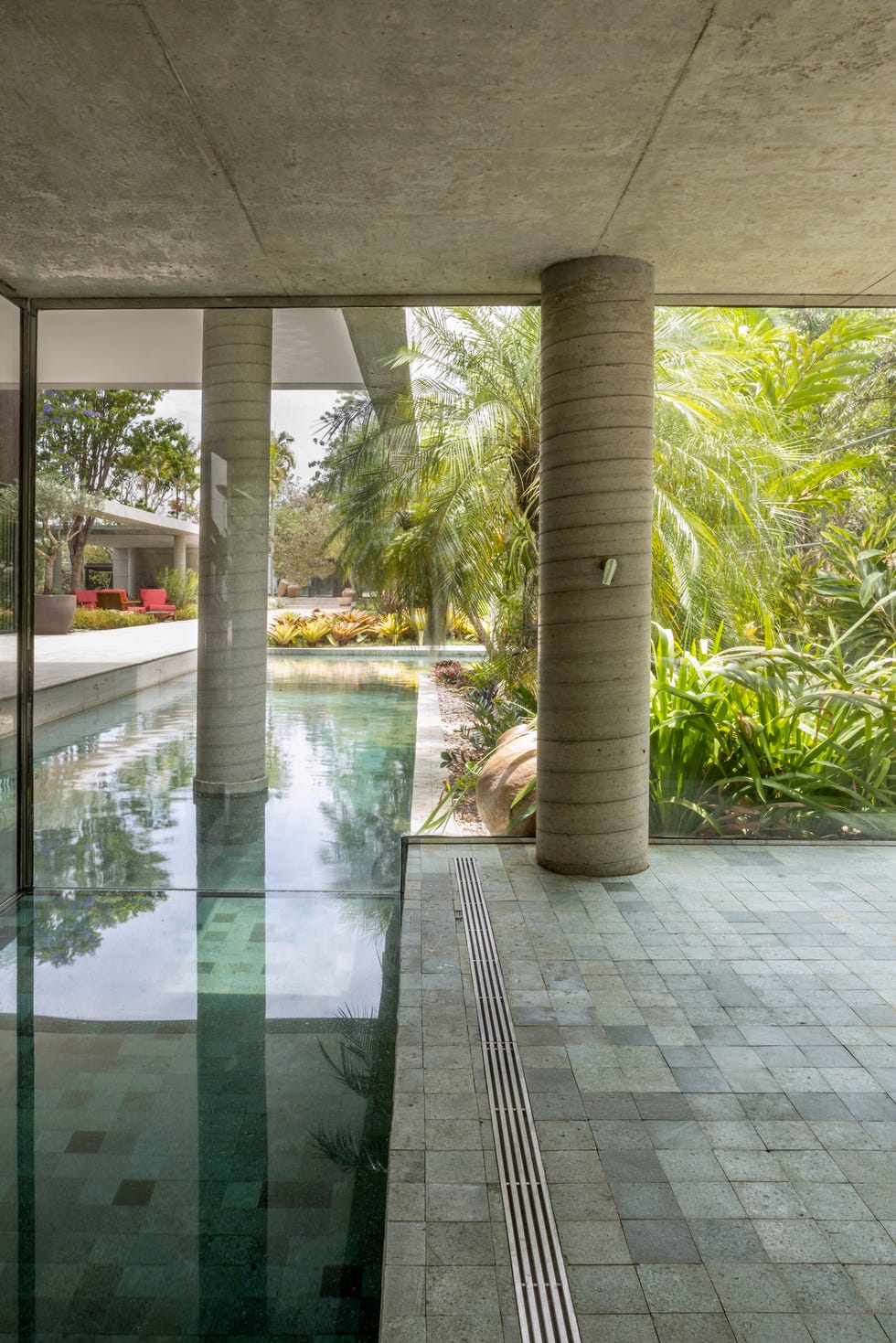 casa de hormigon con piscina que combina estructura brutalista, ventilacion cruzada y diseno tropical a medida