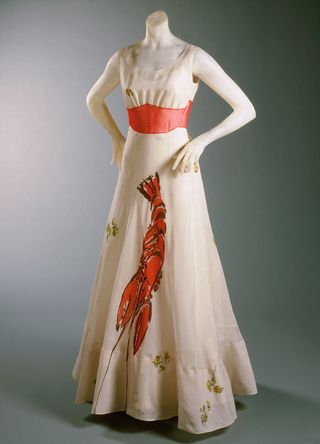 a long white elsa schiaparelli designed dress with the image of a lobster on the front