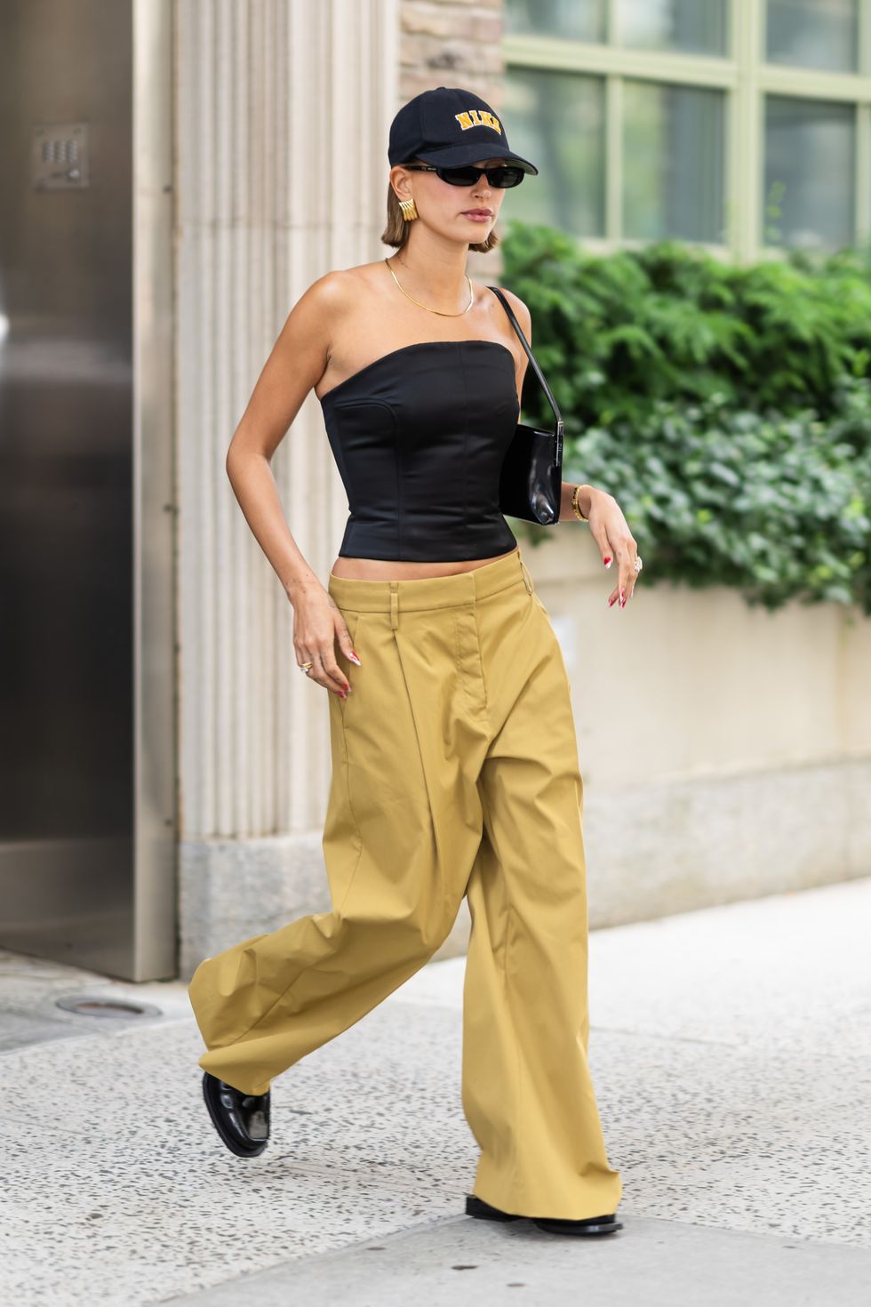 06152023 exclusive hailey bieber is pictured stepping out in new york city the american supermodel wore a nike baseball cap, black corset top, mustard yellow trousers, and black loafers salestheimagedirectcom please bylinetheimagedirectcomexclusive please email salestheimagedirectcom for fees before use