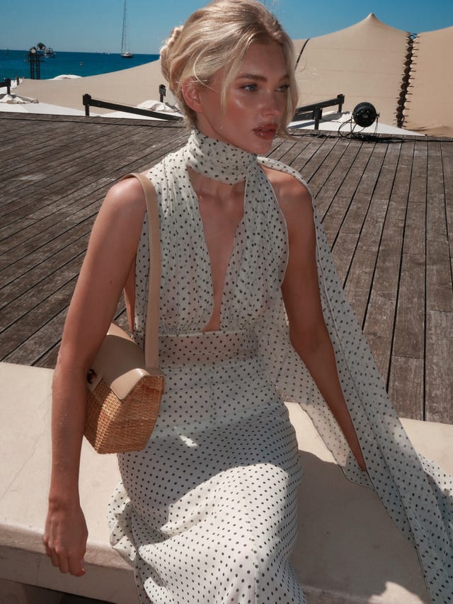 Elsa Hosk com vestido echarpe Helsa e bolsa de palha Chanel