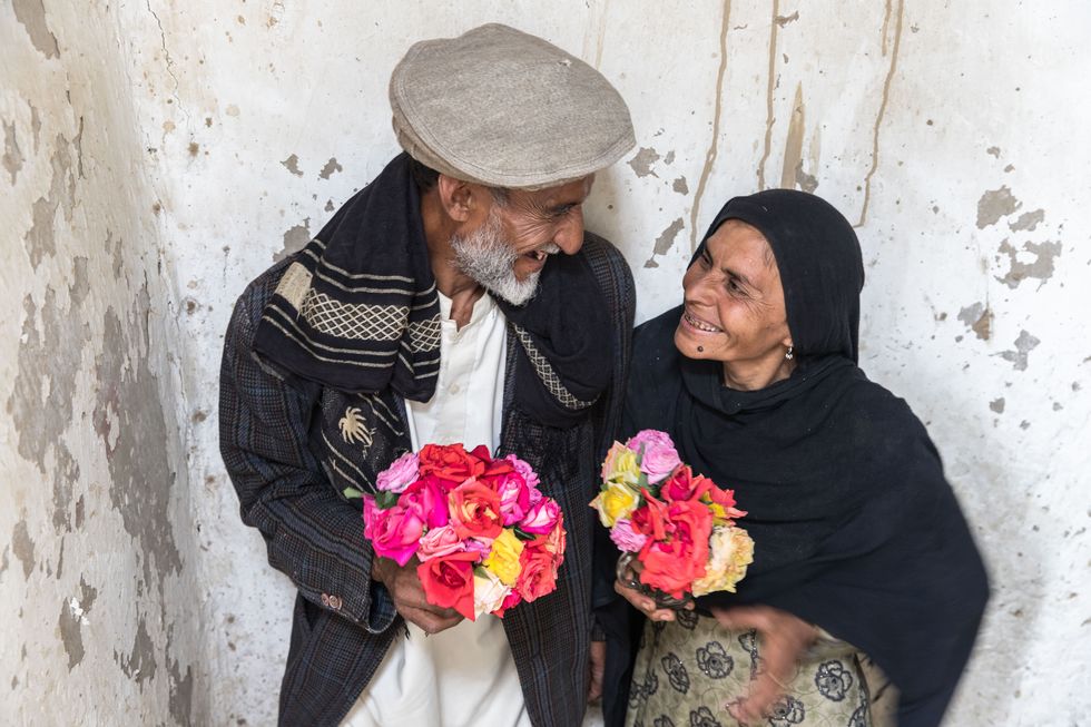 a man and woman holding flowers