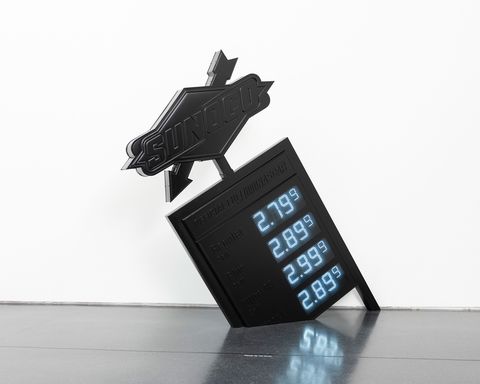 conceptual gas station sign in all black set on an angle on the floor with prices for gas at 279