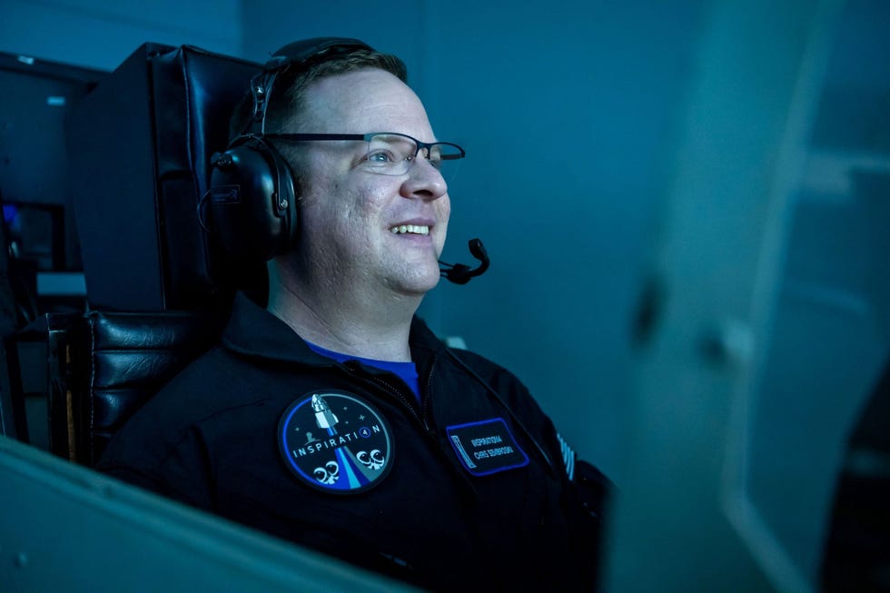 Op het Space Camp in Huntsville Alabama zit Chris Sembroski lid van de Inspiration4bemanning in een vluchtsimulator