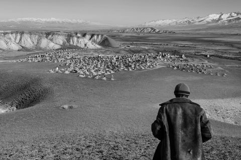 Een jonge herder wandelt naar de begraafplaats nabij het dorp KaraSuu in de provincie Naryn