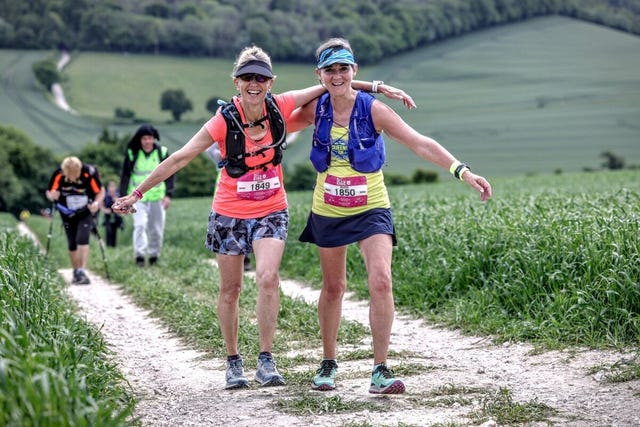 two woman smiling on a trail run