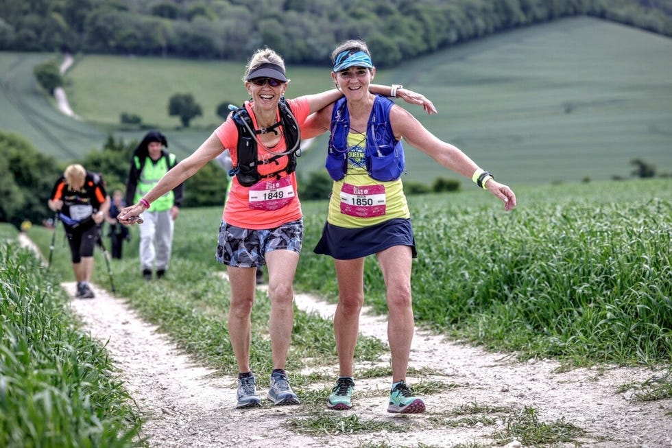 two woman smiling on a trail run