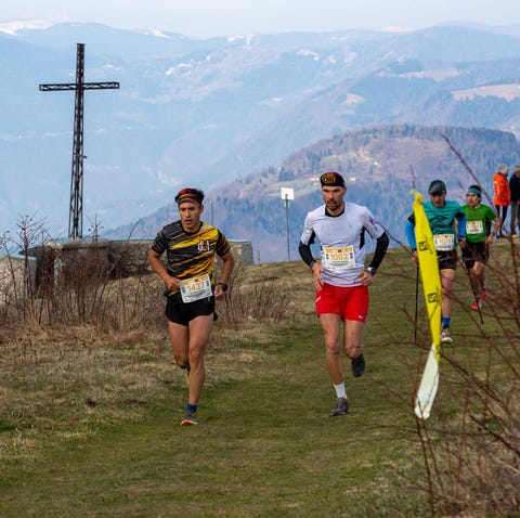 a group of people running on a trail with a tower in the background