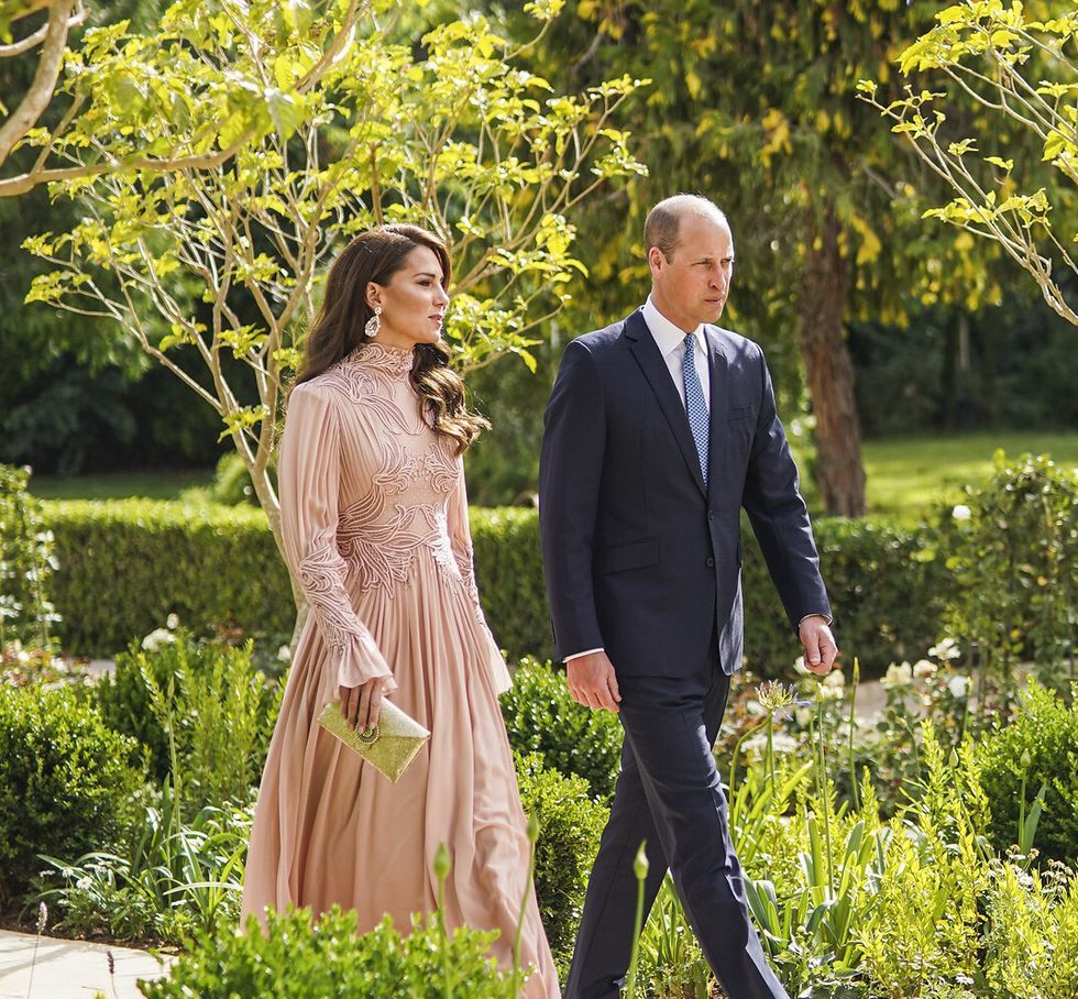 a man and woman walking in a garden