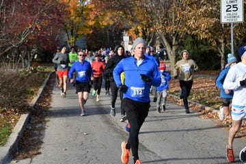 participants in a running event along a treelined path