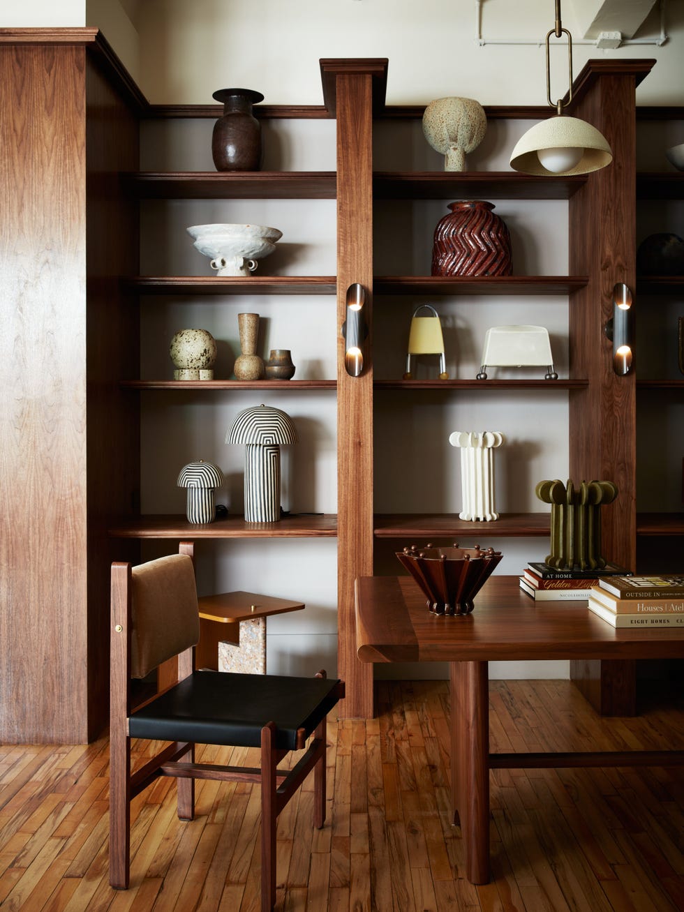 Modern interior featuring wooden shelves with various decorative vases and a chair