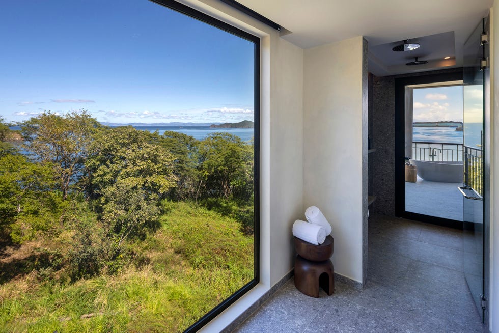 Room with large window showcasing coastal view