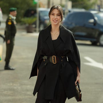 A woman in a stylish black outfit walking on a street