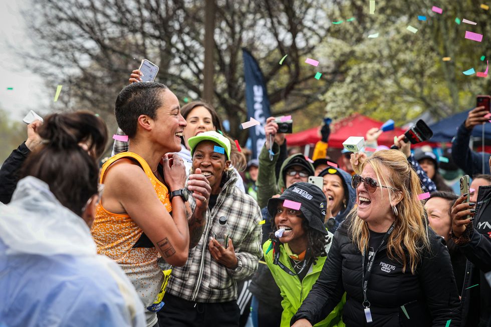 a runner gets a boost from spectators at the mine 21 cheering section of the 2023 boston marathon