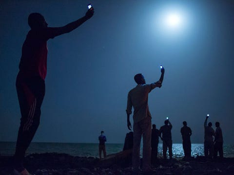 In 2013 vertrok schrijver Paul Salopek op een ruim 33000 kilometer lange tocht over vier continenten in het voetspoor van 60000 jaar menselijke migratie Fotograaf John Stanmeyervergezelde Salopek tijdens het eerste deel van zijn reis Deze opname maakte hij van Somalirs die in de stad Djibouti in het gelijknamige land bij de zee samenkomen om goedkoop signaal voor hun mobiele telefoons op te vangen