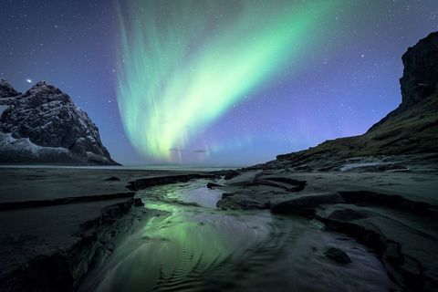 De stranden op de Lofoteneilanden zijn vol van dit soort waterwegen die kleine riviertjes uitsnijden in het zand Wat ik bijzonder vind aan deze foto is de manier waarop de aurora reflecteert in het water