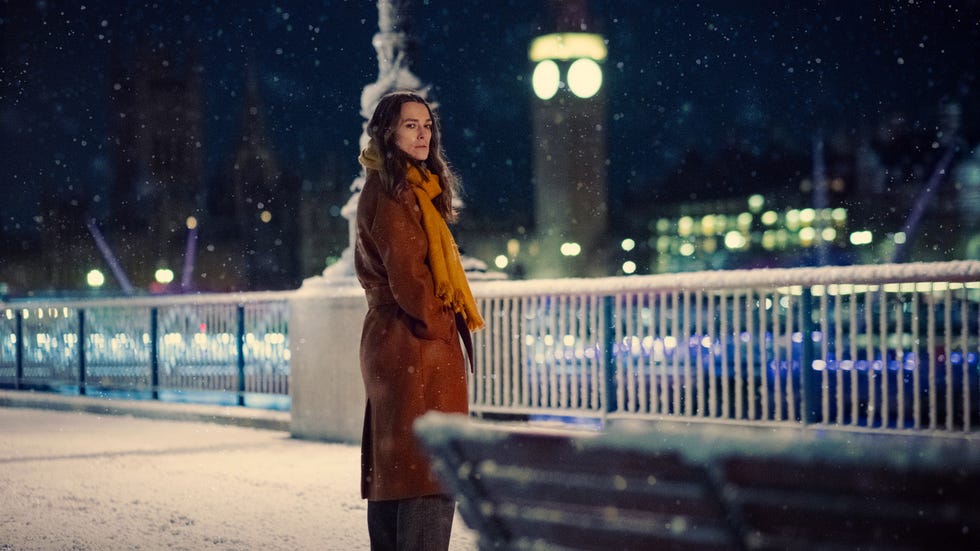 A person stands on a snow-covered promenade at night