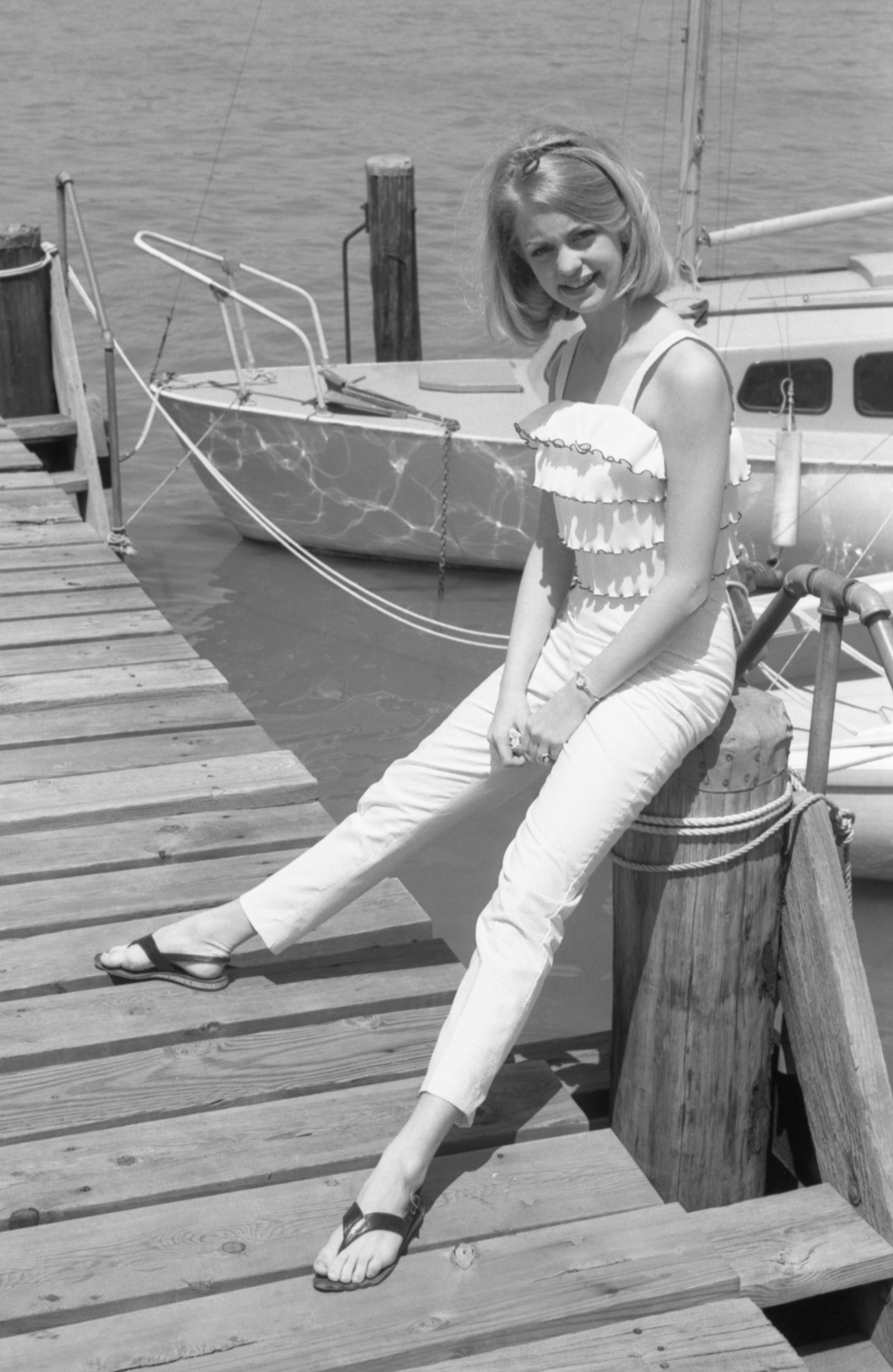 portrait of american dancer and future actress goldie hawn, dressed a ruffled top, jeans, and sandals, as she sits on a piling at a boat marina, washington dc, may 28, 1964 photo by joseph klipplegetty images